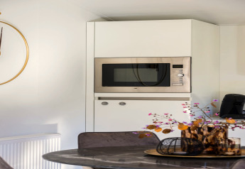 Moderne keuken met ingebouwde magnetron, koffiemachine en stijlvolle decoratie bij Holiday Park Latour 8, Nederland.