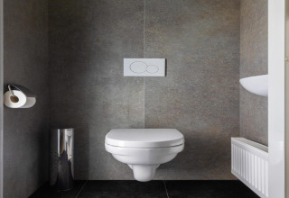 Moderne, wandhangende wc bij Holiday Park «Latour 8» in Nederland met minimalistisch interieur.