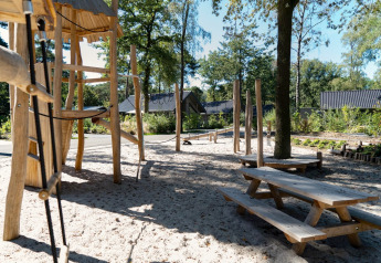 Speeltuin met houten speeltoestellen en picknicktafels bij Holiday Park Latour 8 in Nederland.