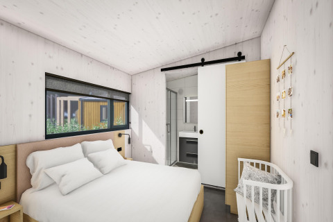 Modern bedroom with double bed, crib, and sliding door to bathroom in Holiday Park Klein Vink 25, Netherlands.