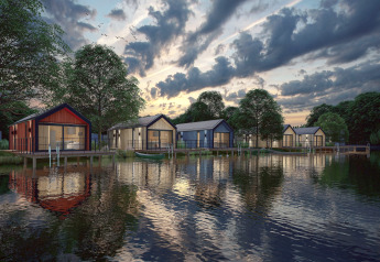 Evening view of Holiday Park Klein Vink 24 in the Netherlands with waterfront lodges by the lake.