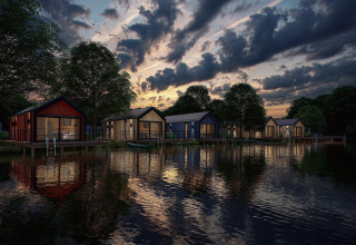 Aftenstemning ved Holiday Park Klein Vink 24 i Nederlandene med moderne hytter ved søens bred.