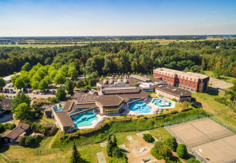 Oversigtsbillede af et luksuriøst glamping-resort med swimmingpools, hovedbygninger og naturskønne omgivelser.