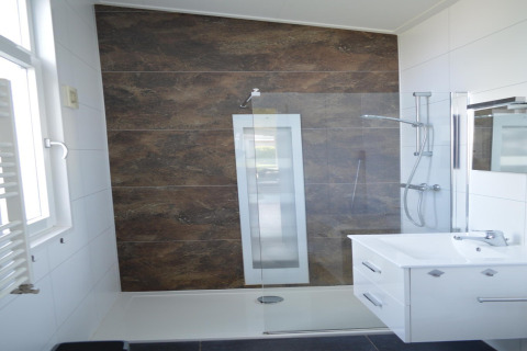 Bagno moderno con sunshower, divisorio in vetro e lavabo bianco presso il lodge «Biebosch» nei Paesi Bassi.