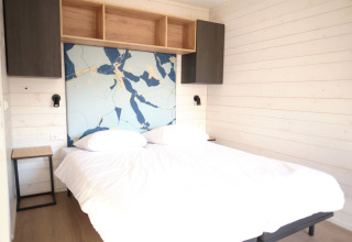 Slaapkamer in Resort «Gulpen 3» in Nederland met tweepersoonsbed, houten wanden en moderne inrichting.