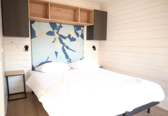 Camera da letto al Resort «Gulpen 3» nei Paesi Bassi, letto matrimoniale e pareti in legno dal design moderno.