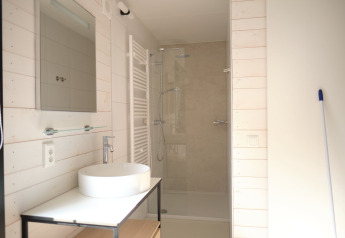 Bagno moderno al Resort Gulpen 3 nei Paesi Bassi, con doccia, lavabo bianco e specchio.