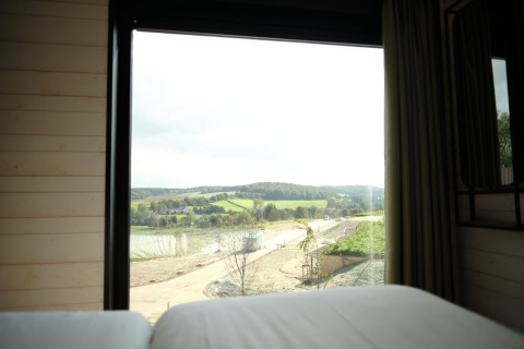 Uitzicht vanuit het raam bij Resort Gulpen 3 in Nederland op glooiende heuvels en landschap.