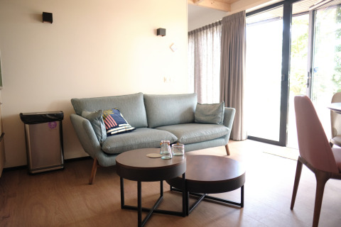 Modern living room in Resort Gulpen 2, Netherlands, featuring a sofa, table, and bright glass doors.