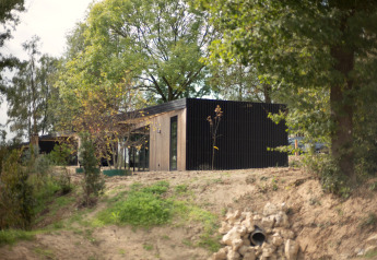 Moderne lodge bij Resort Gulpen 2 in Nederland, omgeven door groen en een natuurlijke omgeving.