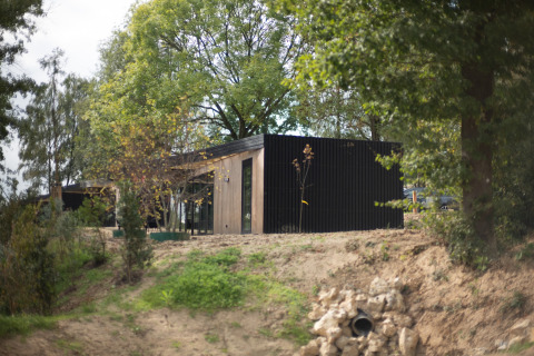 Modern lodge at Resort Gulpen 2 in the Netherlands, surrounded by greenery and natural landscape.