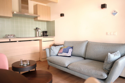 Modern lodge living area at Resort «Gulpen 2» in the Netherlands, featuring a kitchen and sofa.