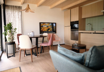 Sala de estar y cocina de planta abierta moderna en Resort «Gulpen 2», Países Bajos, con decoración de madera.