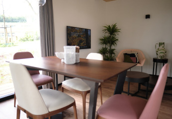 Moderne spisestue i Resort Gulpen 1, Nederlandene, med træbord, stole og indretning ved vindue.