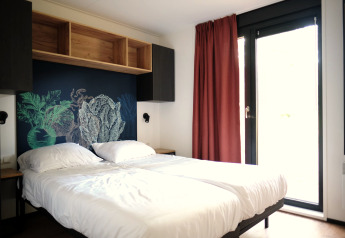 Chambre moderne du Resort Gulpen 6 aux Pays-Bas avec lit double, art mural et grandes fenêtres.