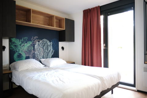 Moderne slaapkamer in Resort Gulpen 6, Nederland, met dubbel bed, muurkunst en grote ramen.