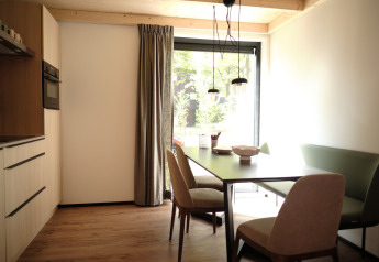 Comedor moderno y luminoso con mesa y sillas en una cabaña del Resort Gulpen 6 en Países Bajos.