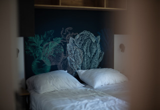 Twee aparte bedden met witte kussens en groenteachtergrond in Resort Gulpen 6 in Nederland.