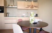 Moderne køkken og spiseområde på Resort Gulpen 5 i Nederlandene med rundt bord og stilfuld vase.