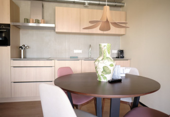Moderne køkken og spiseområde på Resort Gulpen 5 i Nederlandene med rundt bord og stilfuld vase.