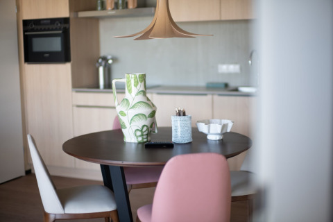 Moderne keuken en eetkamertafel met een vaas en stoelen bij Resort ‘Gulpen 5’ in Nederland.