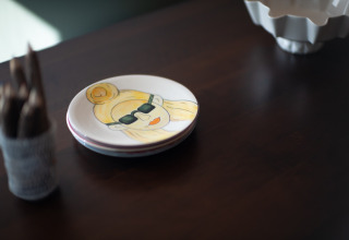 Bord met tekening van persoon met zonnebril op tafel in Resort ‘Gulpen 6’, Nederland.