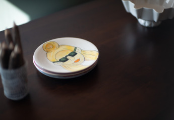 Plato con dibujo de persona con gafas de sol sobre mesa en Resort «Gulpen 6», Países Bajos.