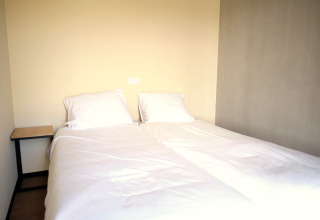 Lit double avec draps blancs et deux oreillers dans une chambre du Resort Gulpen 4 aux Pays-Bas.