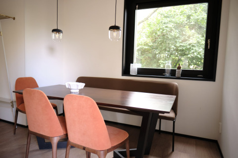 Coin repas au Resort Gulpen 8 aux Pays-Bas avec table moderne, chaises et grande fenêtre sur la verdure.