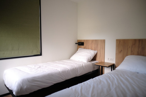 Chambre moderne avec deux lits simples et têtes de lit en bois au Resort Gulpen 8 aux Pays-Bas.