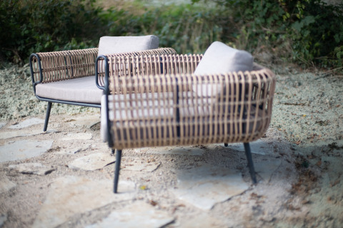 Fauteuils d’extérieur en rotin avec coussins au Resort Gulpen 8, Pays-Bas, sur terrasse en pierre.