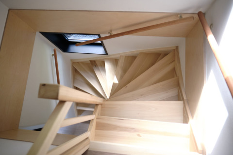Escalier en colimaçon en bois clair avec puits de lumière vu d’en haut au Resort Gulpen 8, Pays-Bas.