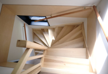 Escalera de caracol de madera clara con tragaluz, vista superior en Resort Gulpen 8, Países Bajos.