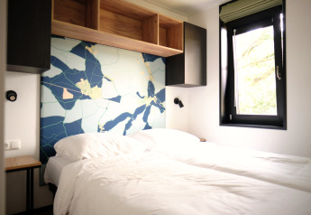 Moderne slaapkamer in Resort Gulpen 8, Nederland, met twee aparte bedden en muurdecoratie.