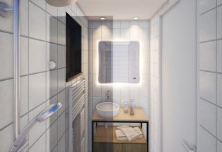Salle de bain moderne du Resort Gulpen 8 aux Pays-Bas, avec lavabo, miroir éclairé et serviettes.