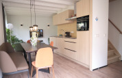 Moderne køkken og spisestue i Resort Gulpen 7-lodgen i Nederlandene med lyse træmøbler.