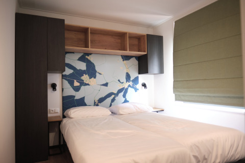 Chambre moderne au Resort Gulpen 7 aux Pays-Bas avec deux lits simples et une fresque murale abstraite.