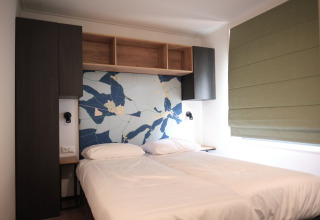 Chambre moderne au Resort Gulpen 7 aux Pays-Bas avec deux lits simples et une fresque murale abstraite.