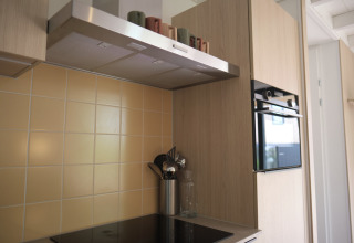 Cuisine moderne au Resort Gulpen 7, Pays-Bas, avec four, plaques, hotte aspirante et ustensiles.