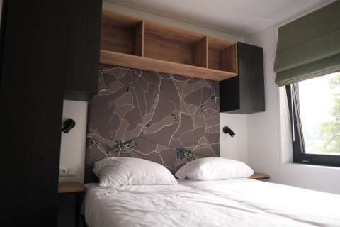 Chambre moderne avec lit double, mur décoratif et fenêtre au Resort Gulpen 7 aux Pays-Bas.