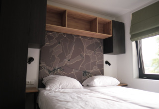 Chambre moderne avec lit double, mur décoratif et fenêtre au Resort Gulpen 7 aux Pays-Bas.
