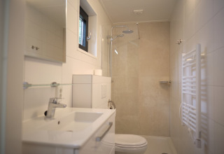 Salle de bains moderne au Resort Gulpen 7 aux Pays-Bas avec douche à l’italienne et porte-serviettes.