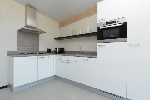 Moderne keuken in Sea Lodges ‘Bloemendaal 5’ in Nederland met witte kasten en een strak werkblad.