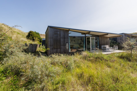 Moderne lodge bij Sea Lodges Bloemendaal 5 in Nederland, omringd door grasduinen en rustige natuur.