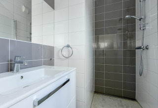 Moderne badkamer met witte lavabo, chroom kraan en inloopdouche in Sea Lodges «Bloemendaal 5», Nederland.