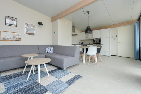 Moderne leefruimte en keuken in Sea Lodges Bloemendaal 4 strandhuis, Nederland, met grijze accenten.