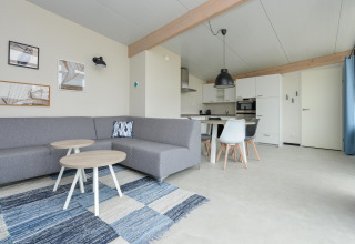 Moderne leefruimte en keuken in Sea Lodges Bloemendaal 4 strandhuis, Nederland, met grijze accenten.