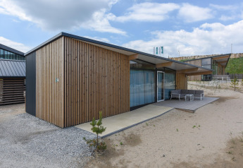 Modernes Strandhaus Sea Lodges Bloemendaal 4 mit Holzverkleidung und Terrasse in den Niederlanden.