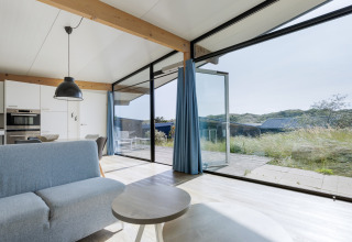 Heldere woonruimte in Sea Lodges Bloemendaal 4, Nederland, met grote ramen en zicht op de duinen.