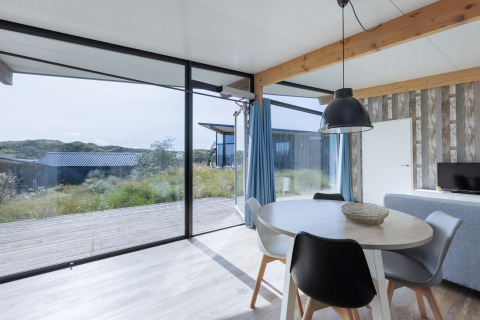 Heldere leefruimte in Sea Lodges «Bloemendaal 4» met grote ramen en duinzicht in Nederland.